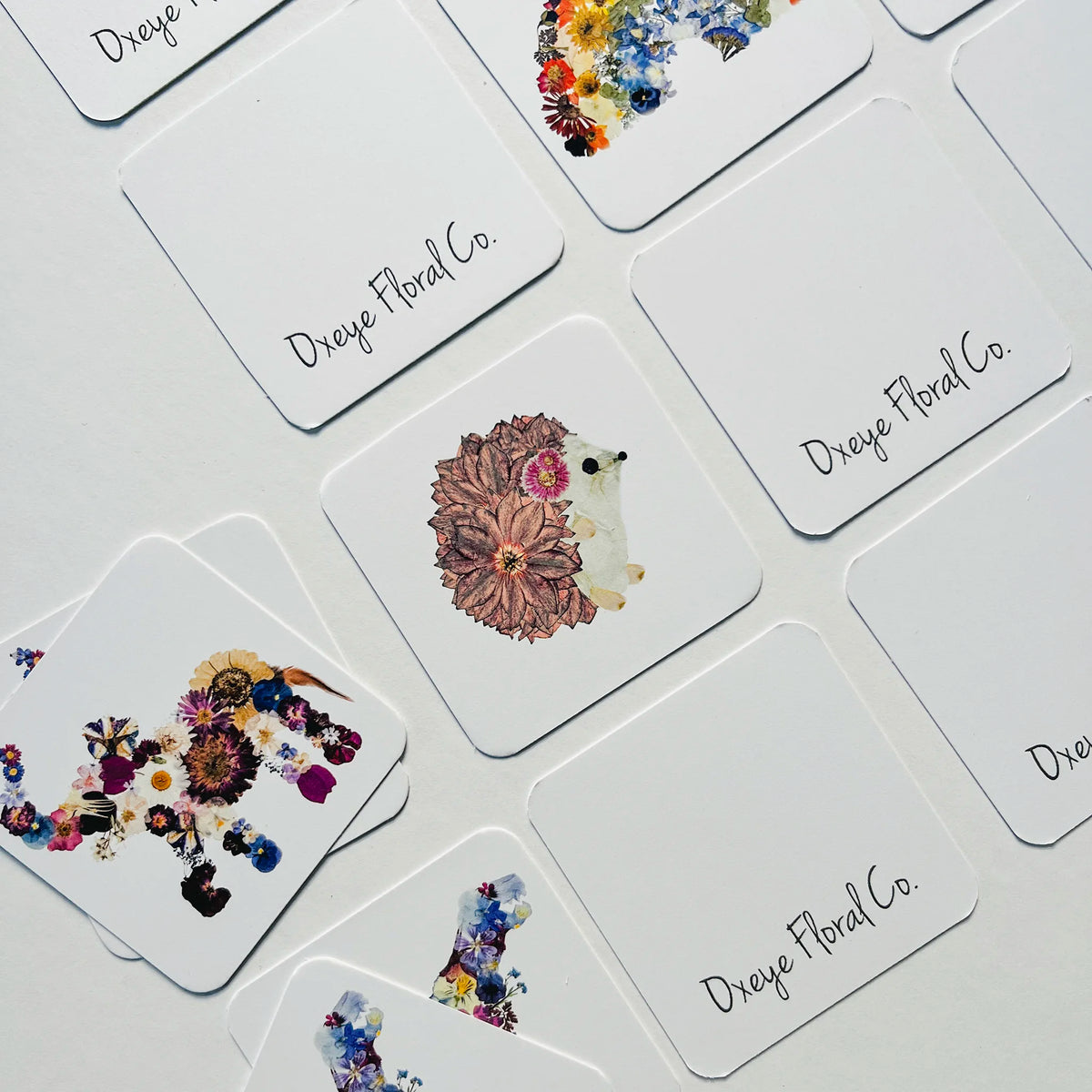 Memory game cards with floral animal designs o a white surface.