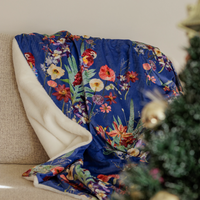 Tropical parrot and flower blanket with blue background on a couch with a Christmas tree in the foreground