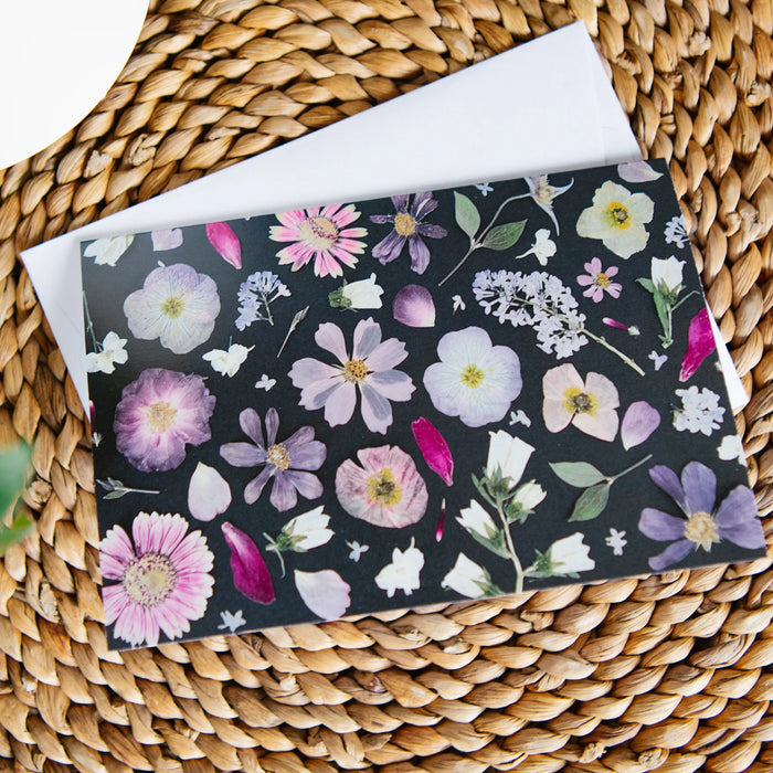 Pressed flower greeting card on a woven surface