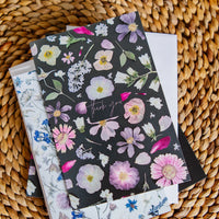 Pressed floral cards on a woven surface