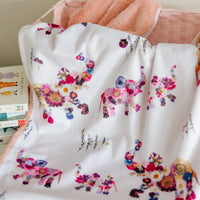 Colorful baby blanket featuring floral elephants on a white background