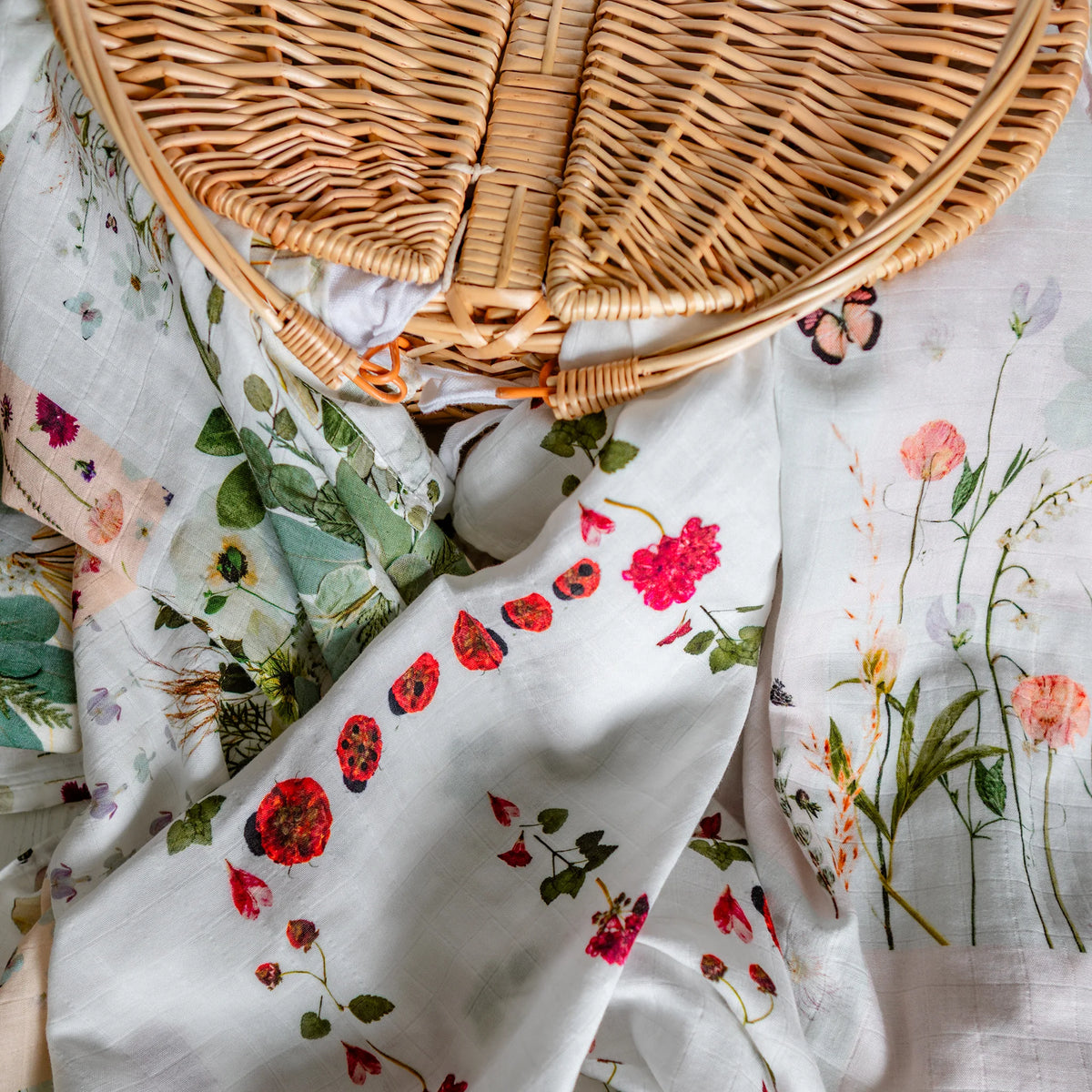 Floral-patterned newborn swaddles with a wicker basket