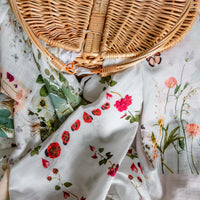 Floral-patterned newborn swaddles with a wicker basket