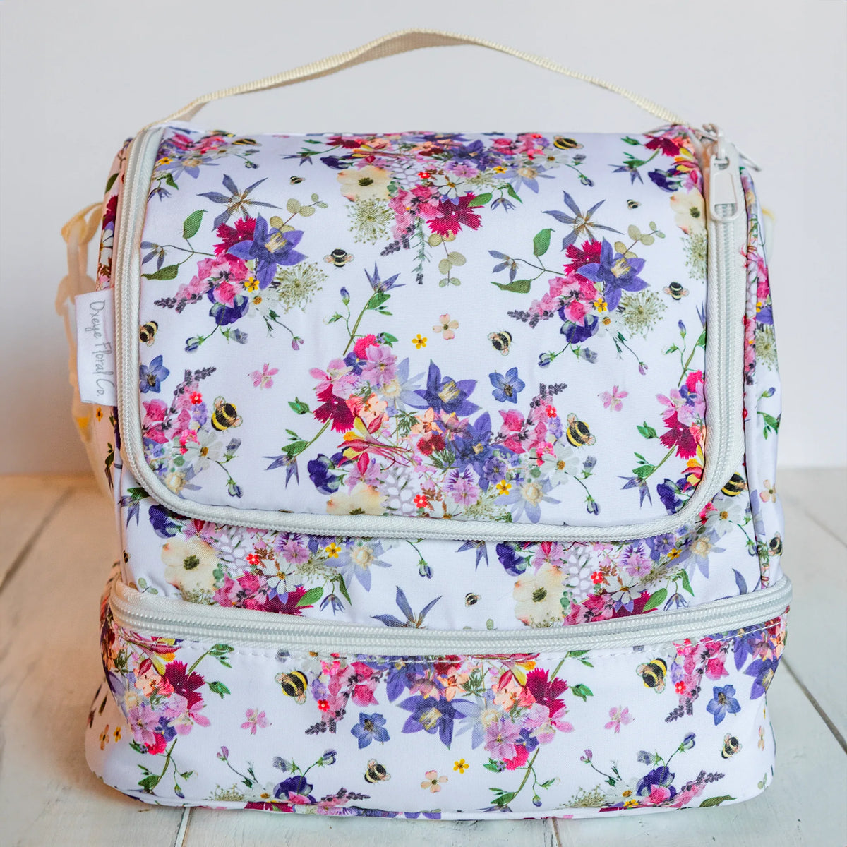 Floral-patterned cooler bag on a light wooden surface