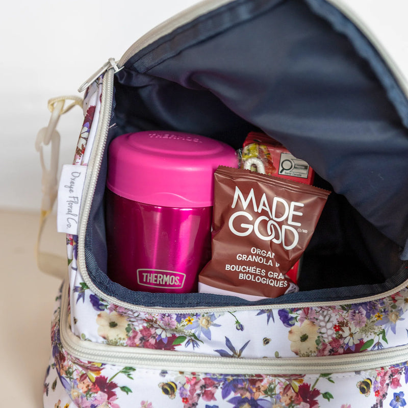 Floral cooler bag with zip pocket and snacks inside.