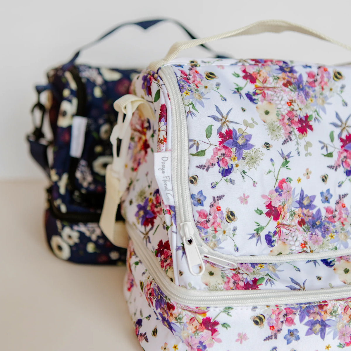 Floral-patterned lunch bags with Oxeye Floral Co logo on a light background