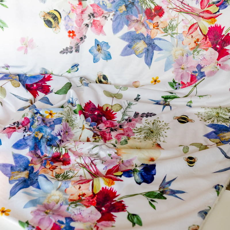 Pressed floral blanket with colorful flowers and bees on a white background