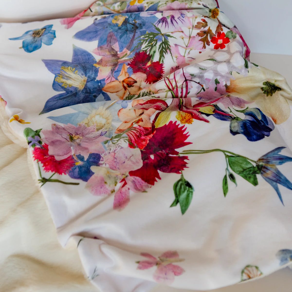 Folded floral-patterned blanket on a white surface