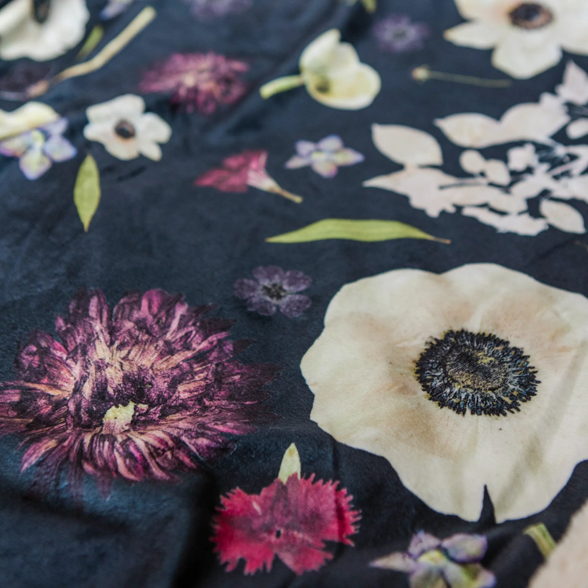 Blanket featuring a floral pattern on a dark fabric background