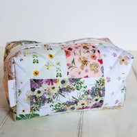 mini cosmetics bag with floral patchwork print on white background