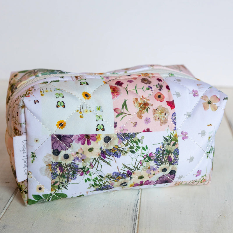 mini cosmetics bag with floral patchwork print on white background