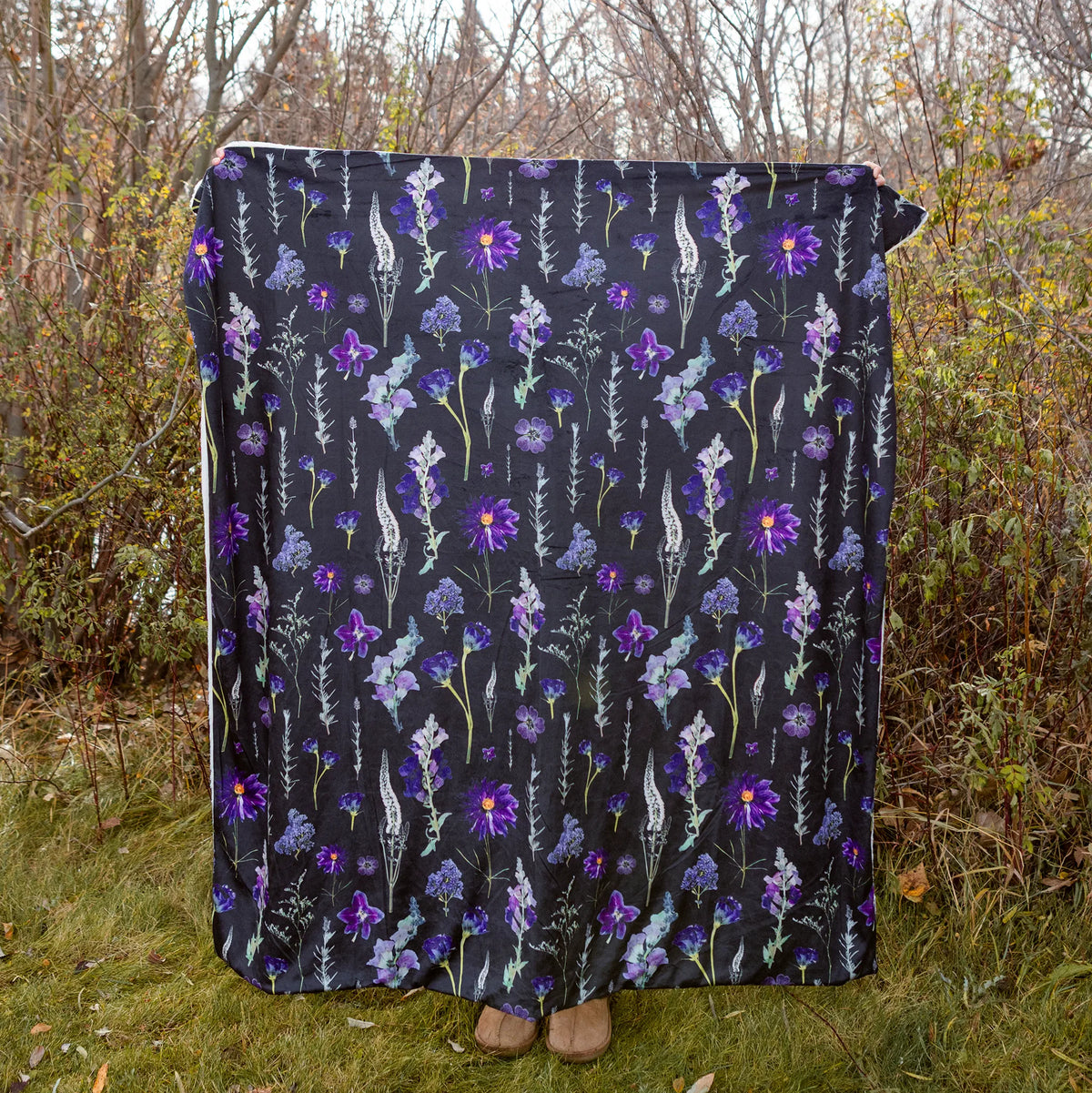Floral patterned blanket draped over a person in a natural setting