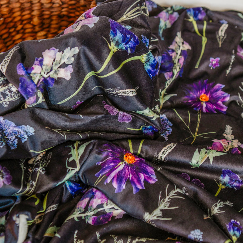 Floral blanket with purple and blue flowers on a dark background