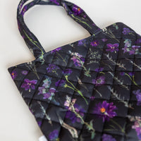 Closeup of a black and purple pressed flower tote with quilted fabric