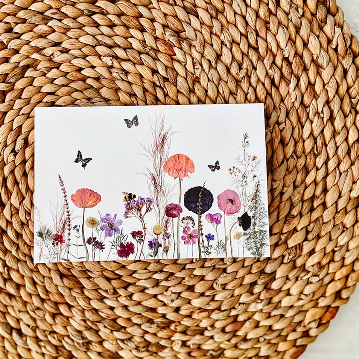 Pressed flower greeting card with butterflies and bees