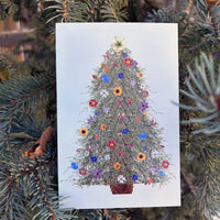 Card with a decorative Christmas tree made of flowers, surrounded by pine branches.