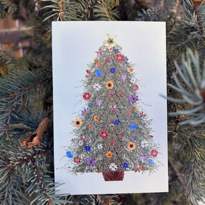 Card with a decorative Christmas tree made of flowers, surrounded by pine branches.
