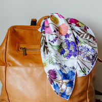 Pretty meadow floral bandana accessory knotted on a bag handle