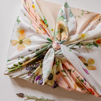 Box wrapped in a patchwork floral square of fabric and neatly knotted at the top